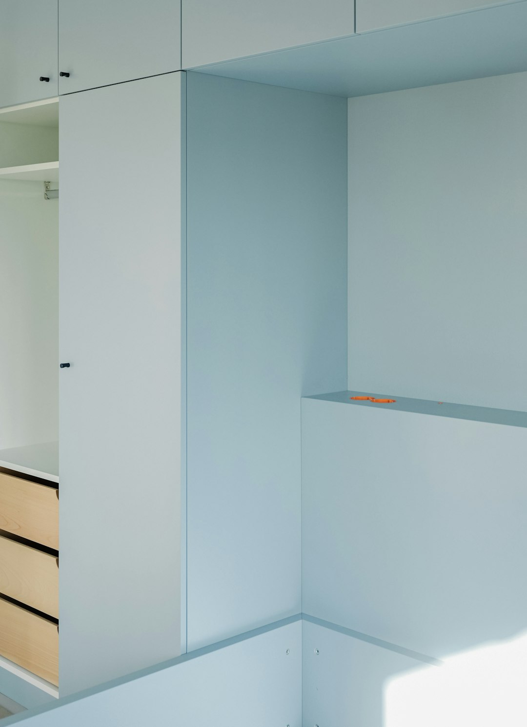 modern-bedroom-with-light-blue-walls-and-wooden-drawers-npjp36qo4rk